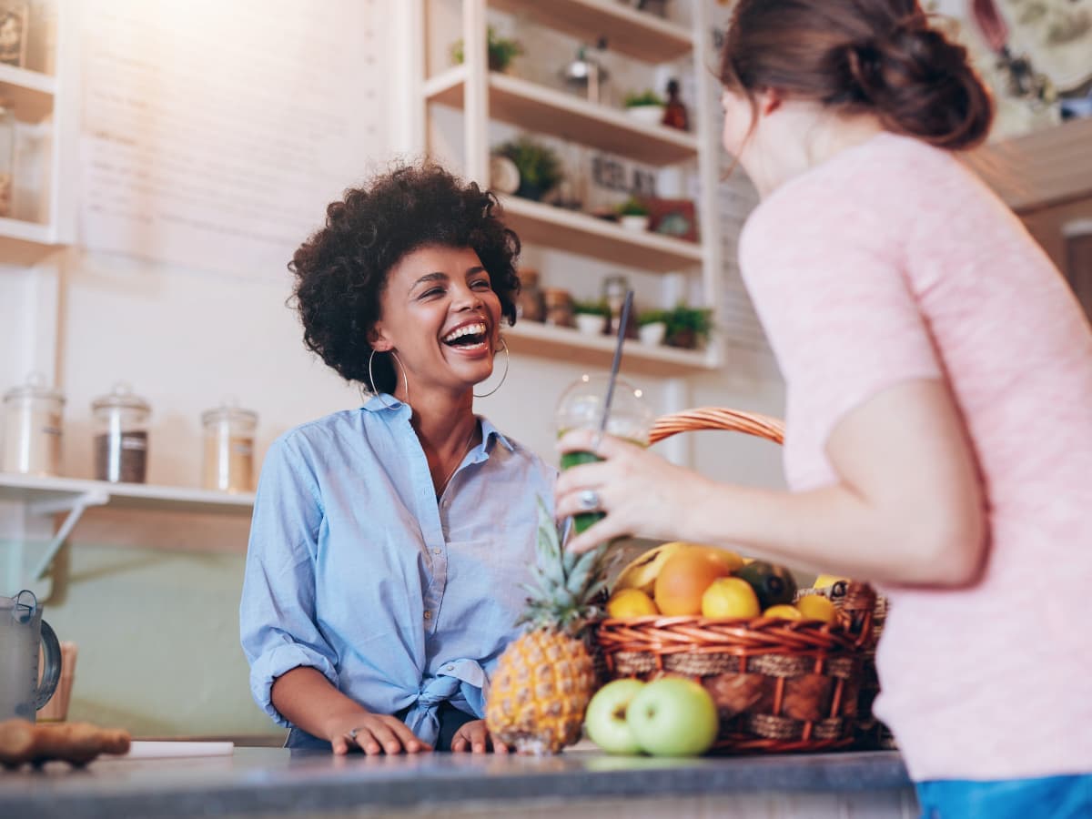 Two girls contact each other with some fresh fruits on hands